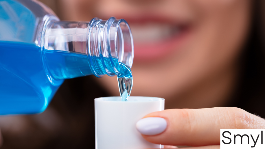 Blue mouthwash pouring into a cup.